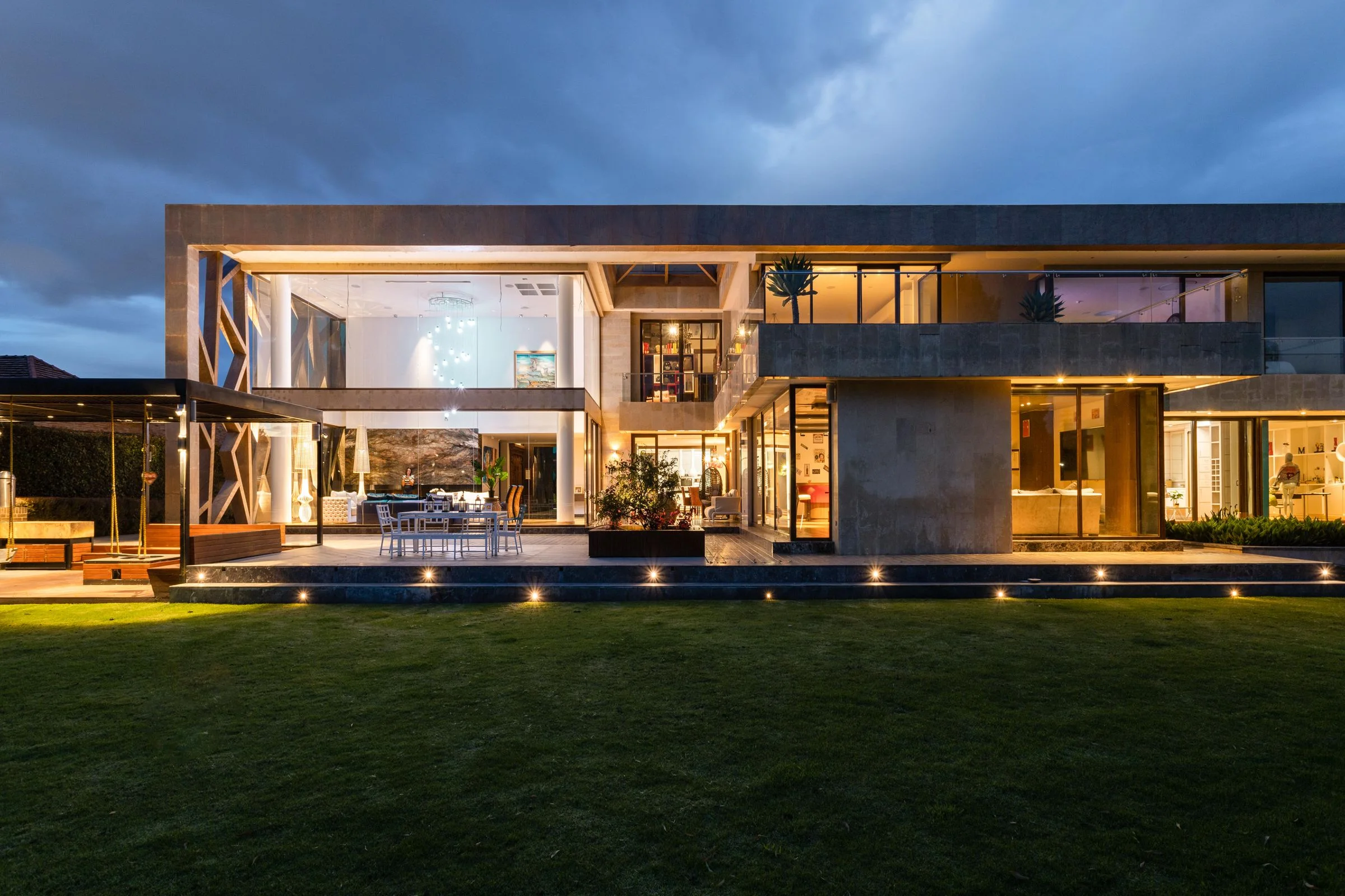 Modernes Architektenhaus zur blauen Stunde mit warm beleuchteten Fensterfronten